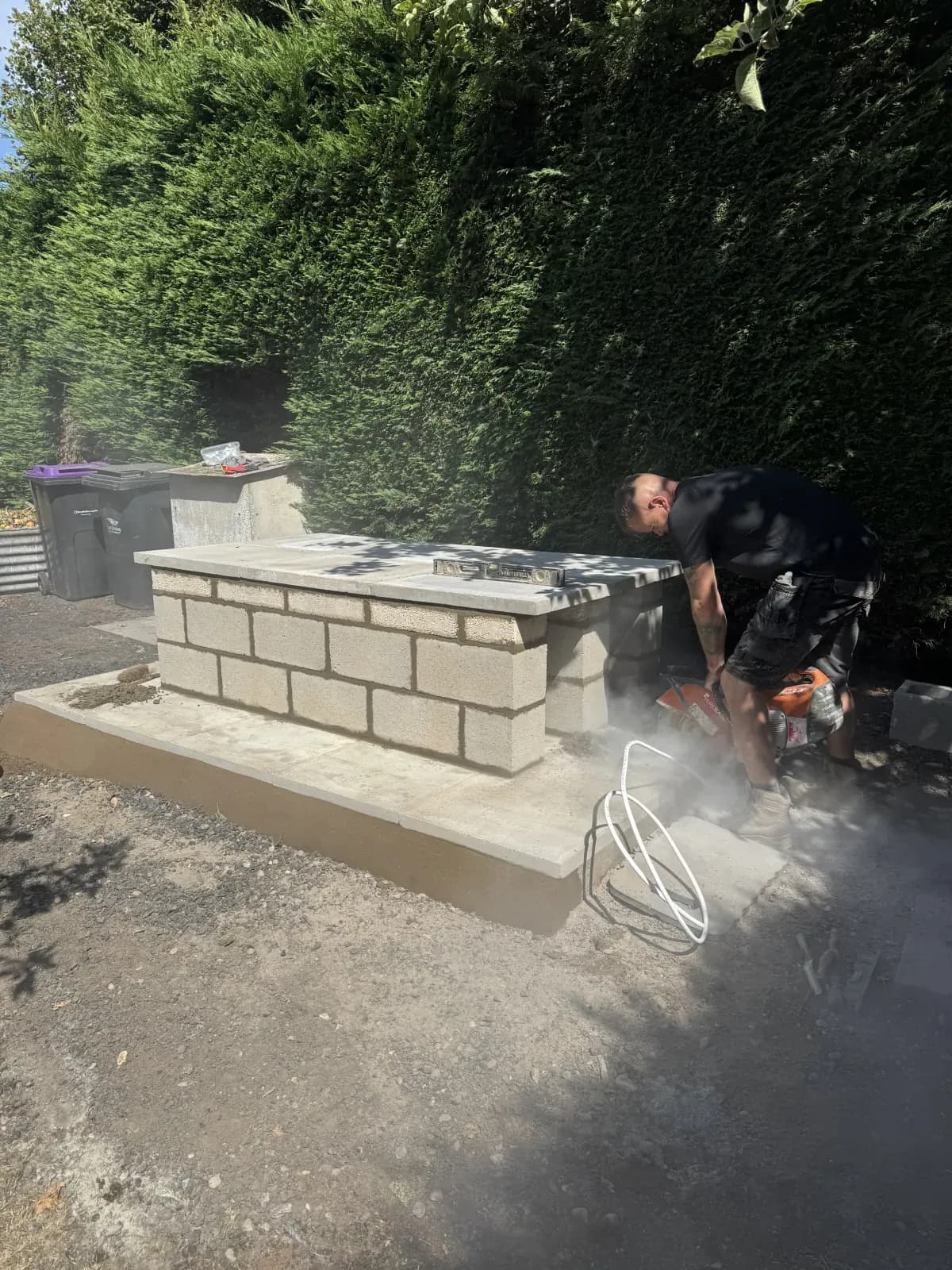 Engineer cutting the top slabs while finishing a raised oil tank base