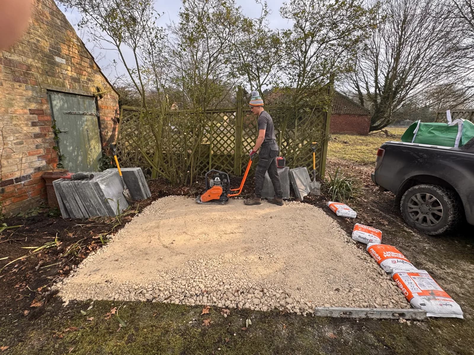Engineer compacting the aggregate sub-base for a new oil tank foundation